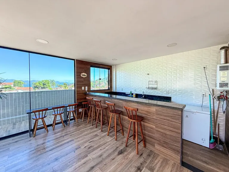 Espaço gourmet da cobertura com bancada e vista para o mar